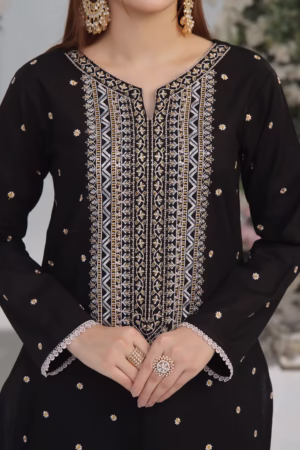 Full-length image of a woman wearing a black embroidered dress with a floral background.