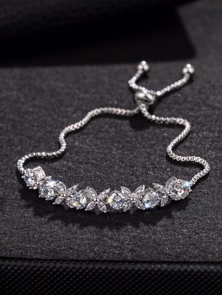 Elegant Silver Adjustable Bracelet with Sparkling Stones A dazzling silver bracelet with cubic zirconia stones on a black background.