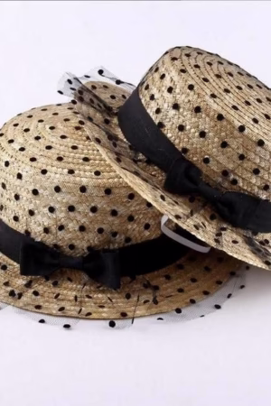 Vintage-style polka dot straw hat with a black ribbon bow and net overlay, designed for women. Perfect for summer fashion and sun protection.
