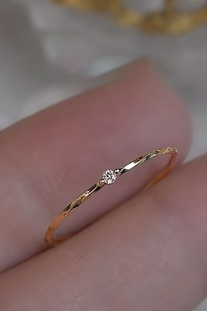 A thin gold ring with a delicate diamond accent, perfect for a minimalist style.