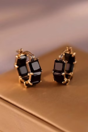 Gold-tone hoop earrings with rectangular black gemstones.