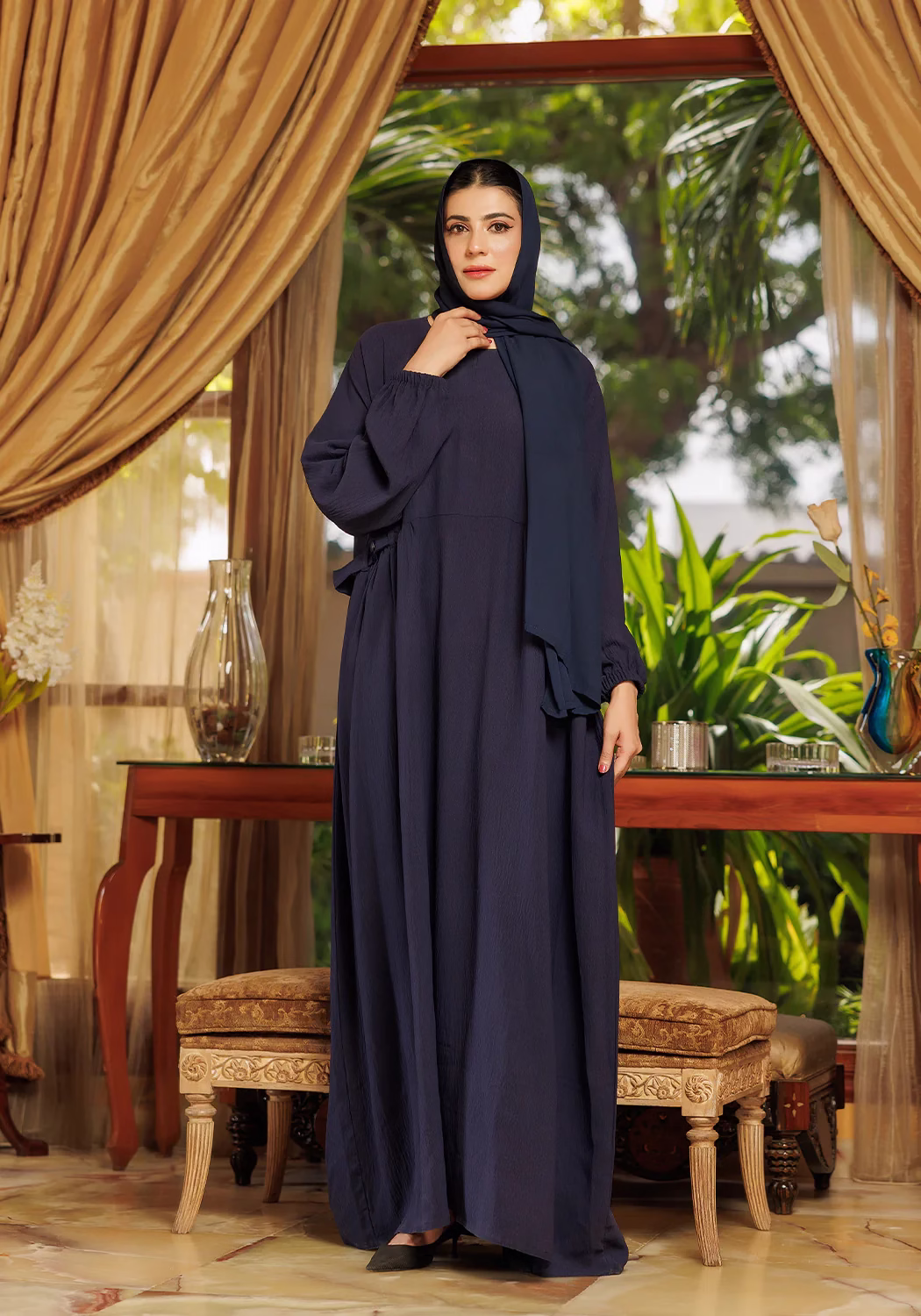 Loop Button Blue Abaya: Stylish Modesty with Unique Button Detailing A Loop Button Blue Abaya displayed on a mannequin, showcasing its delicate button details and flowing, soft fabric.
